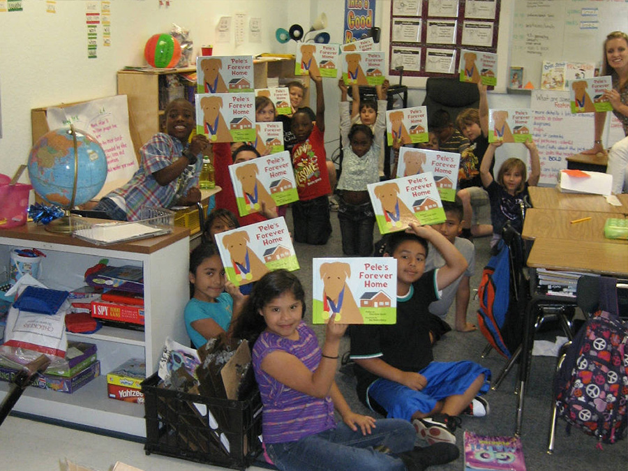 Blackburn Elementary School kids hold up their copies of Pele's Forever Home